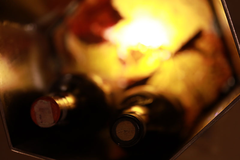 Foto di una cantina ben illuminata con bottiglie di vino perfettamente conservate.