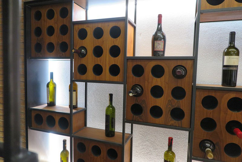 Immagine di una cantina ben organizzata con etichette di vini in primo piano e condizioni ideali di conservazione.