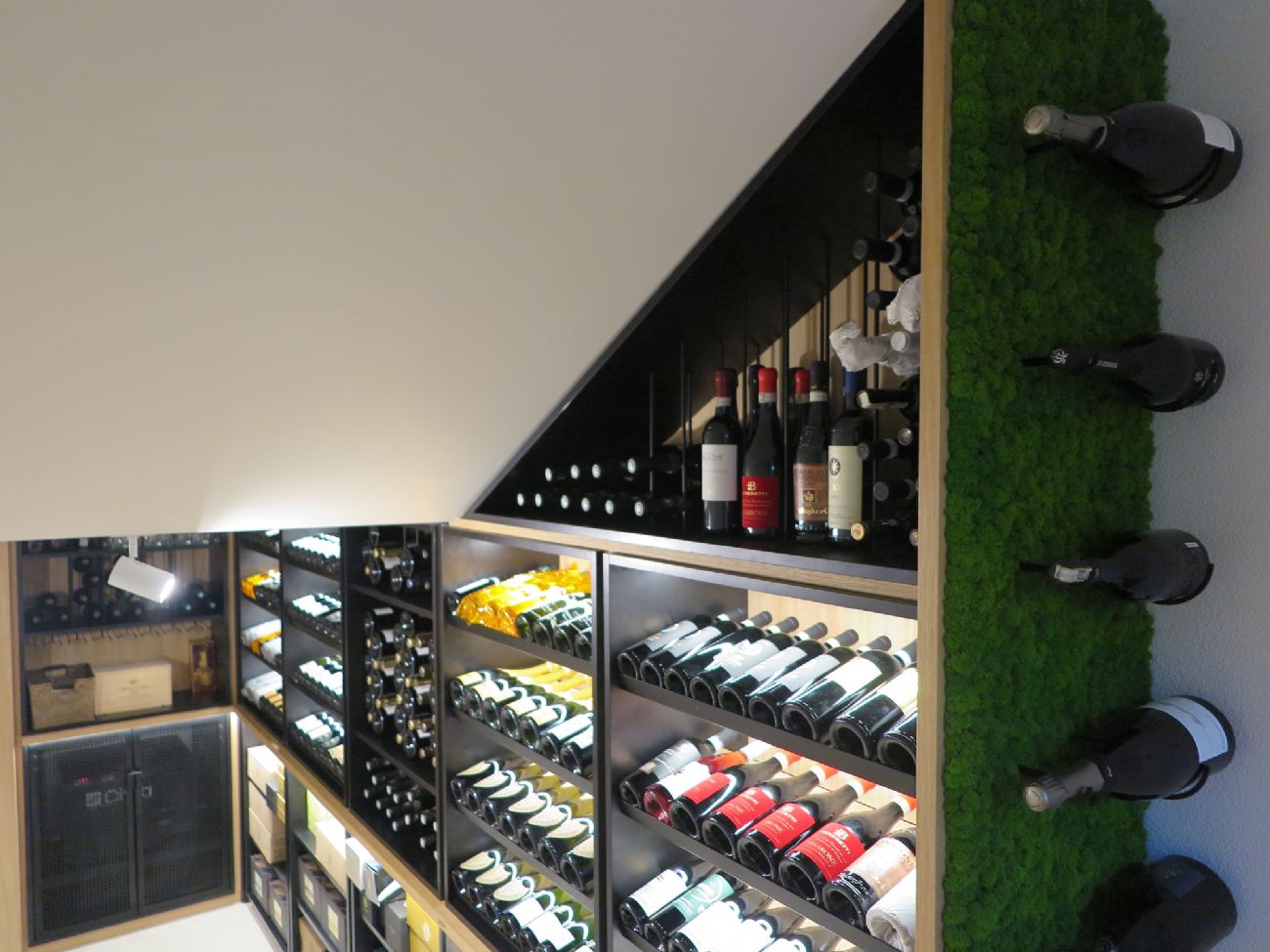 Speciale design che coniuga eleganza e funzionalità nel soggiorno di quest'attico, ospitando una collezione di vini privata. Particolare rilievo il contrasto materico tra legno di rovere, green moss e carpenterie metalliche.